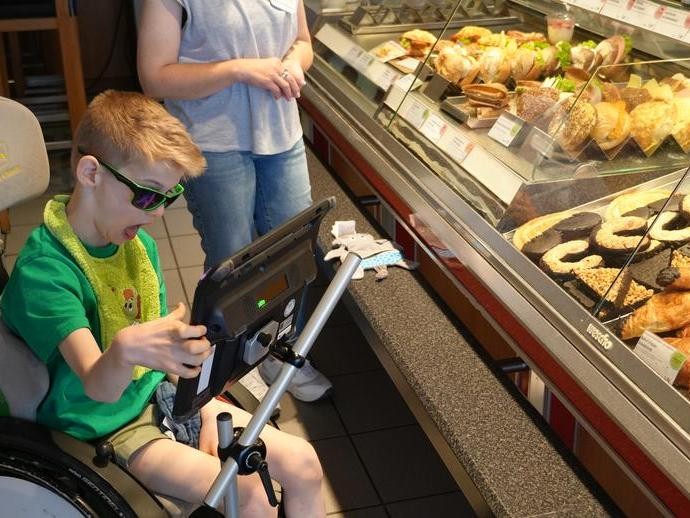 Schüler mit Talker in der Bäckerei (vergrößerte Bildansicht wird geöffnet)
