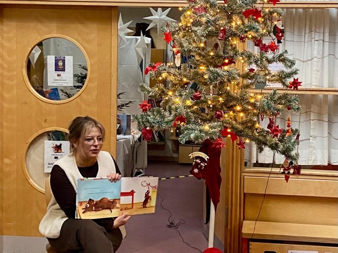 Bilderbuch in der Hand eines Kindes im Rollstuhl (vergrößerte Bildansicht wird geöffnet)