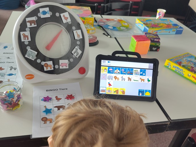 Schüler mit Talker beim Bingo spielen (vergrößerte Bildansicht wird geöffnet)