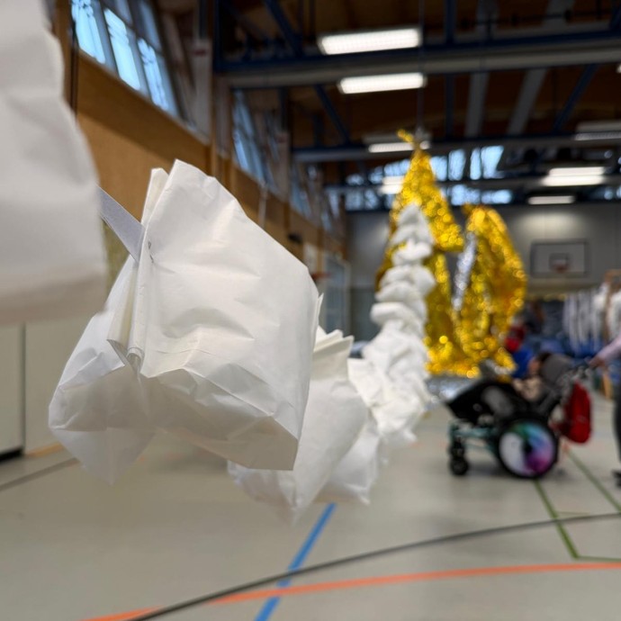 Hand streicht durch herabhängende Bänder (vergrößerte Bildansicht wird geöffnet)