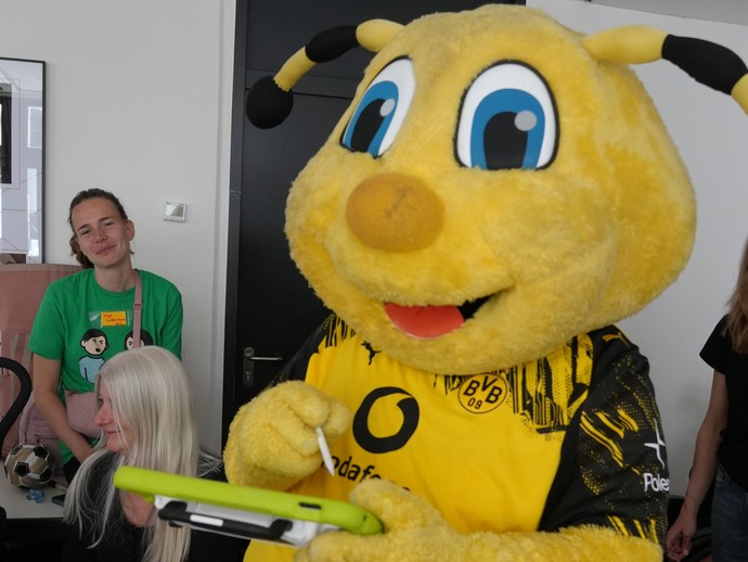 Maskottchen Emma mit Talker (vergrößerte Bildansicht wird geöffnet)