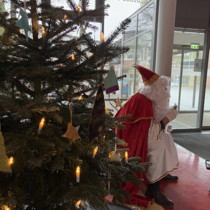 Nikolaus sitzt neben dem Weihnachtsbaum (vergrößerte Bildansicht wird geöffnet)